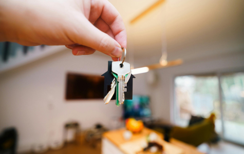 Hand holding rental keys with the living room in the background